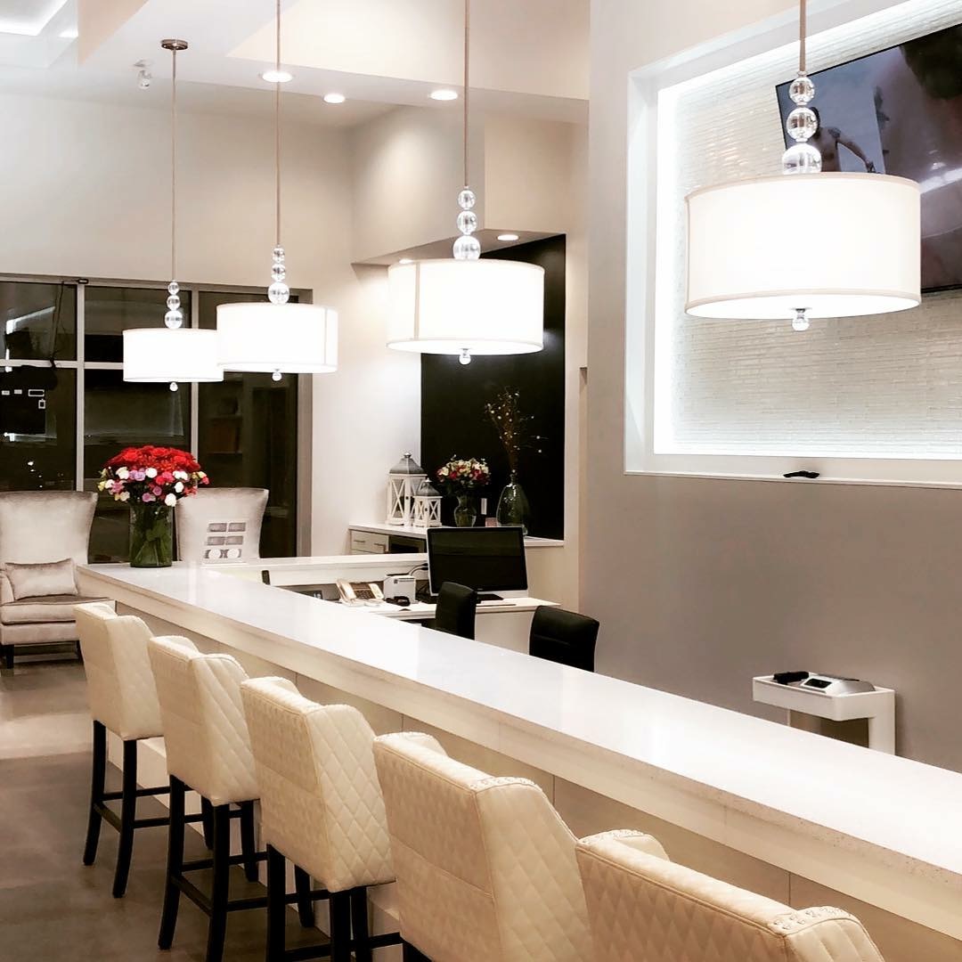 Evening view of manicure stations with pendant lights and flowers