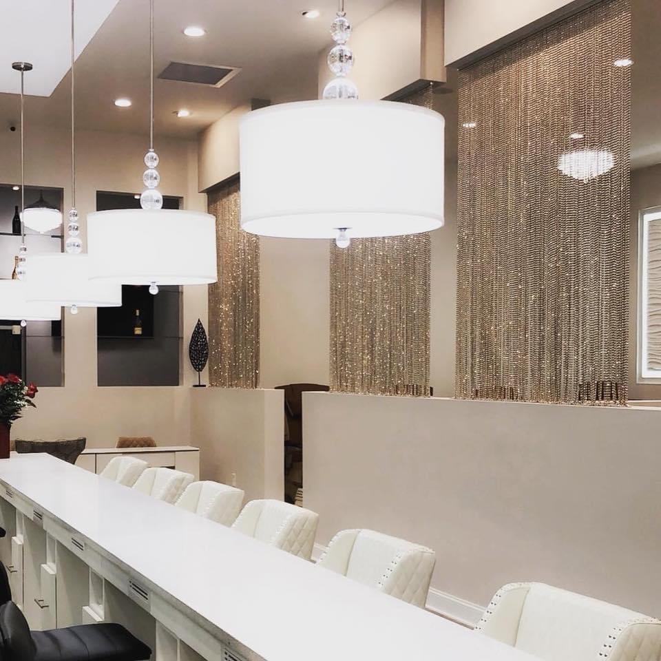 Manicure bar with gold chain curtains and white drum pendants