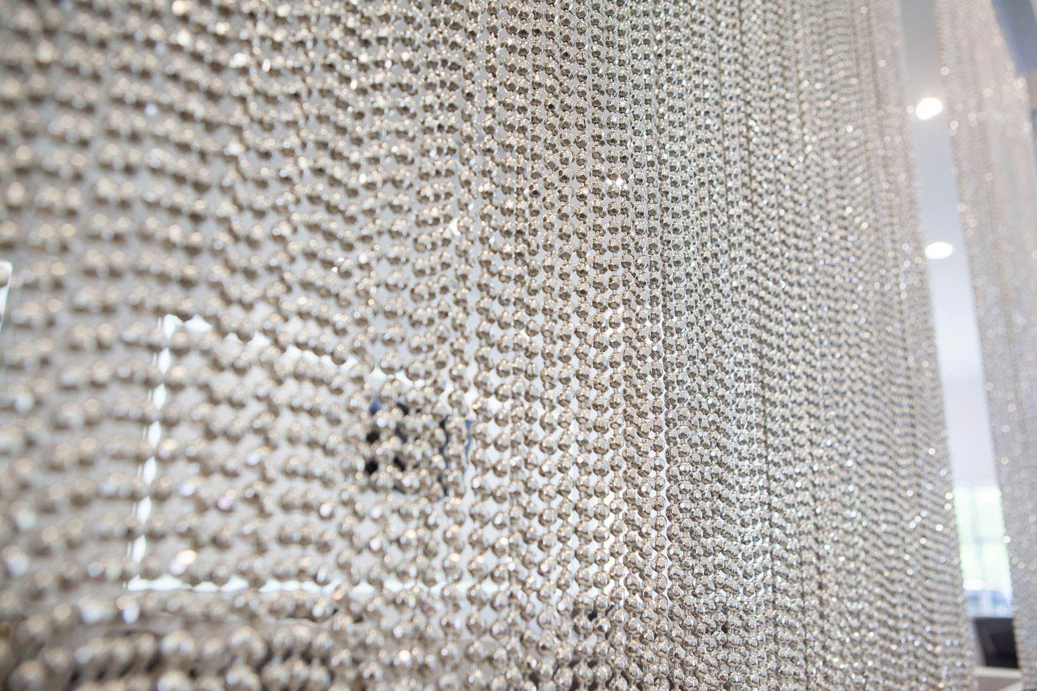 Close-up detail of shimmering silver chain curtain partition